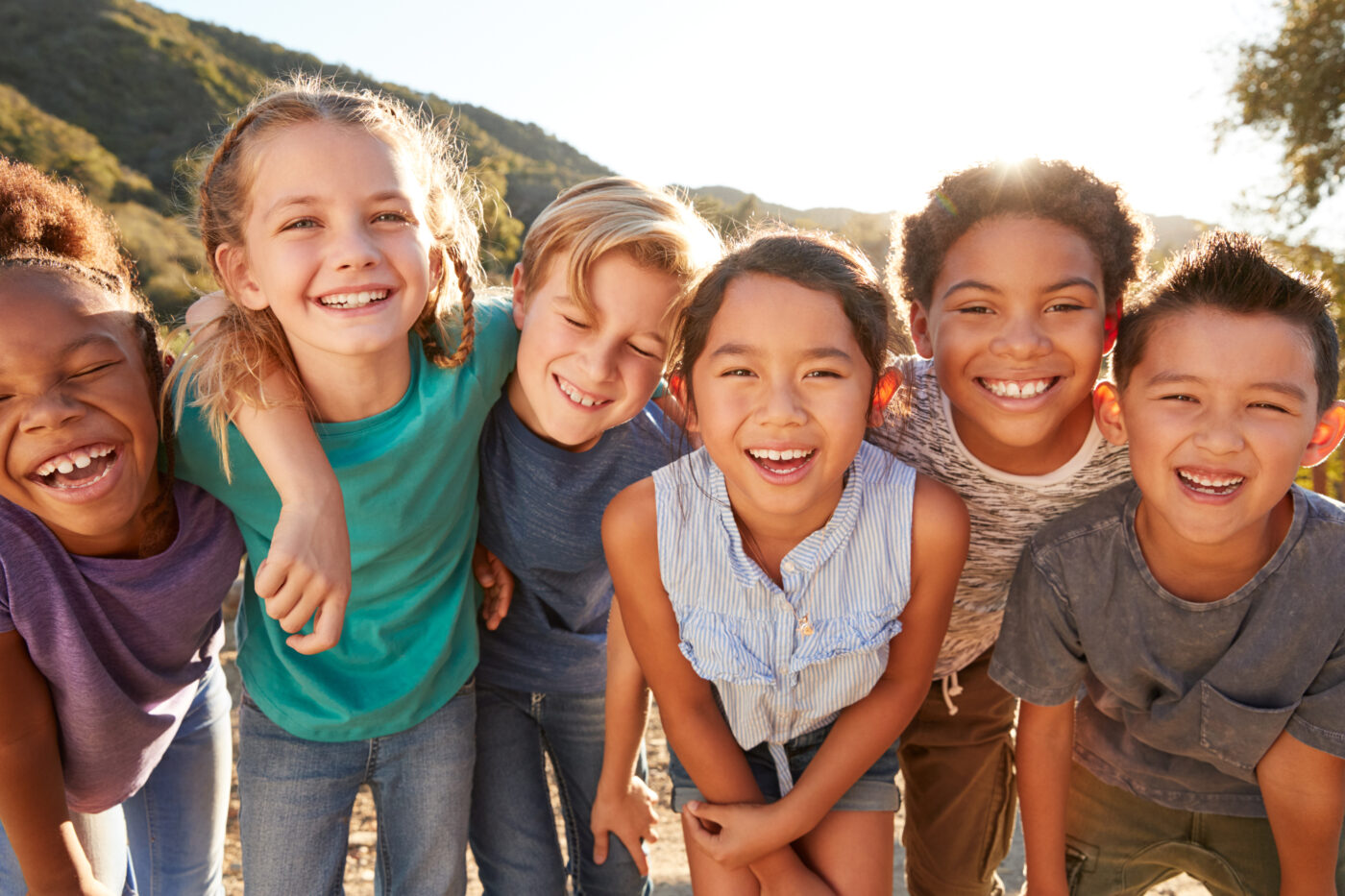 portrait of multi cultural children hanging out with friends in countryside together