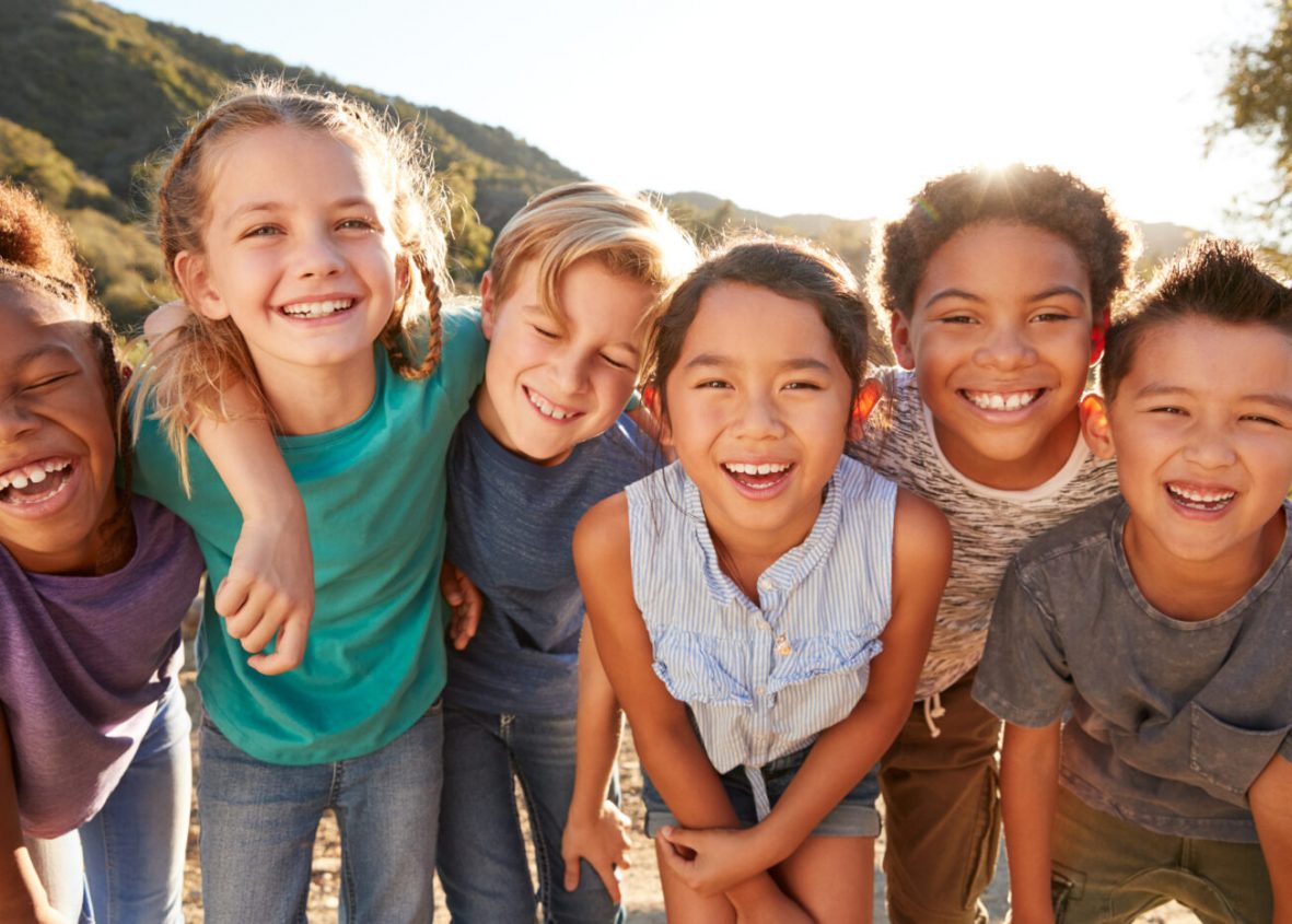 portrait of multi cultural children hanging out with friends in countryside together